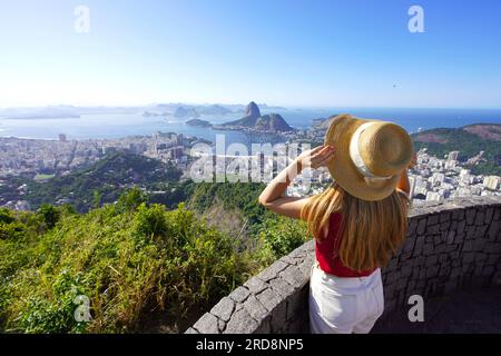 Blick aus der Vogelperspektive auf ein stilvolles Mädchen mit Hut am Aussichtspunkt Rio de Janeiro mit Guanabara Bay, Rio de Janeiro, Brasilien Stockfoto