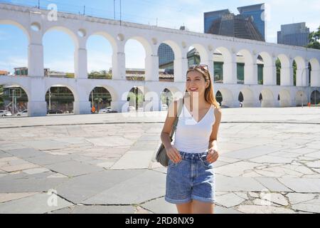 Portrait einer jungen Touristin, die mit Carioca Aqueduct (Arcos da Lapa) in Rio de Janeiro, Brasilien, das Viertel Lapa besucht Stockfoto