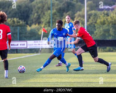 Warrington Rylands Spieler Mo Touray passt den Ball unter Druck eines Stockport Town Spielers im Stockport Sports Village auf einem 3G-Platz Stockfoto