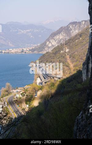 Blick aus der Vogelperspektive auf die Bergstraße und den Tunnel im Wald im Sommer am Comer See Stockfoto