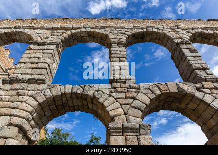 Das Aquädukt von Segovia, Spanien, altes römisches Steingebäude, Symbol von Segovia, Blick aus dem niedrigen Winkel vor blauem Himmel. Stockfoto