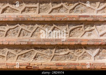 Mittelalterliche Fassade aus Stein und Ziegelbraun und Orange in Segovia, Spanien, mit geometrischen Formen und Linien. Stockfoto