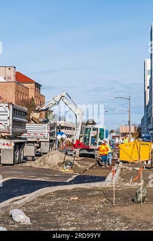 Beim Bau einer Gesundheitseinrichtung lädt der Ladeschaufel Schmutz in einen Muldenkipper. Stockfoto