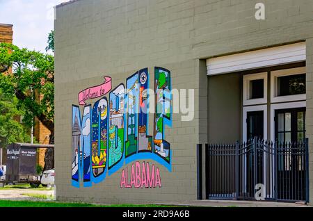 Ein Postkartengemälde begrüßt Besucher von Mobile, 27. Juni 2023, in Mobile, Alabama. Das Wandgemälde enthält Kultszenen aus Mobile Life. Stockfoto