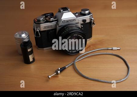 Canon AE-1 SLR-Filmkamera mit Zubehör (Filmrolle und Kabelfreigabe) Stockfoto