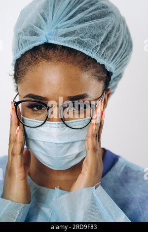 Portrait der jungen afroamerikanischen Ärztin oder Krankenschwester auf medizinischer Schutzkleidung mit Maske Stockfoto