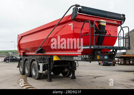 Kirkwall, Orkney Island, Schottland, Großbritannien. Großer rot lackierter Kipperanhänger mit Rollenabdeckung, der in der Nähe des Fährterminals in Kirkwall geparkt ist. Stockfoto