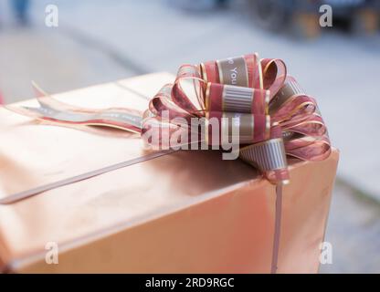 Goldene Geschenkbox mit braunem Band Stockfoto