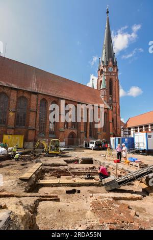 Winsen, Deutschland. 17. Juli 2023. Mitarbeiter des Archäologischen Museums Hamburg graben auf dem Kirchenvorplatz St. Marienkirche in Winsen/Luhe (Bezirk Harburg). Bevor im Rahmen des Stadterneuerungsprojekts „Winsen 2030“ ein Wasserspiel errichtet wird, wird hier die Baugeschichte entziffert. Seit dem Mittelalter befinden sich das Rathaus und ein städtischer Glockenturm an diesem Standort. (Zu dpa: „Like a Puzzle“ – Sonderausgrabungen im Stadtzentrum von Winsen“) Kredit: Ulrich Perrey/dpa/Alamy Live News Stockfoto