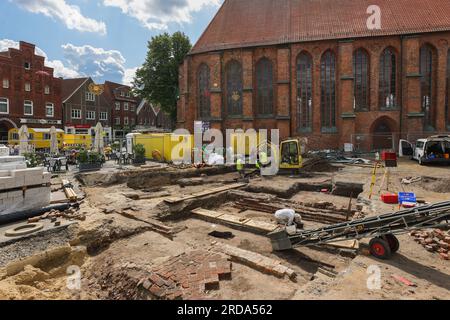 Winsen, Deutschland. 17. Juli 2023. Mitarbeiter des Archäologischen Museums Hamburg graben auf dem Kirchenvorplatz St. Marienkirche in Winsen/Luhe (Bezirk Harburg). Bevor im Rahmen des Stadterneuerungsprojekts „Winsen 2030“ ein Wasserspiel errichtet wird, wird hier die Baugeschichte entziffert. Seit dem Mittelalter befinden sich das Rathaus und ein städtischer Glockenturm an diesem Standort. (Zu dpa: „Like a Puzzle“ – Sonderausgrabungen im Stadtzentrum von Winsen“) Kredit: Ulrich Perrey/dpa/Alamy Live News Stockfoto