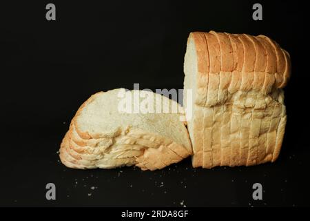 Geschnittenes Brot auf schwarzem Hintergrund. Nahaufnahme des Fotos Stockfoto