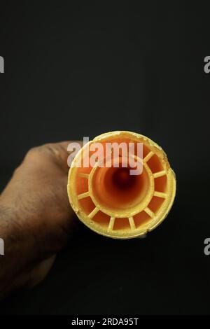 Hände halten eine Waffelmuschel auf schwarzem Hintergrund, Stockfoto Stockfoto