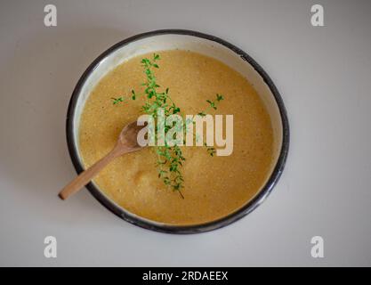 Polenta mit Butter und Parmesankäse in Schüssel auf Betonhintergrund. Gesundes Lebensmittelkonzept. Stockfoto