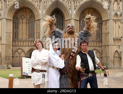 Peterborough, Großbritannien. 18. Juli 2023. Luke Skywalker, Prinzessin Leia, Chewbacca und Han Solo posieren vor der Peterborough Cathedral, bevor eine der größten Star Wars privaten Fansammlungen der Welt in der herrlichen Peterborough Cathedral ab dem 19. Juli zu sehen ist. Die Ausstellung, inoffizielle Galaxien, in der Peterborough Cathedral, umfasst über 120 Ausstellungen, darunter ein lebensgroßer Land Speeder neben seltenen Star Wars-Spielzeugen und -Gegenständen. Peterborough, Cambridgeshire, Großbritannien. Kredit: Paul Marriott/Alamy Live News Stockfoto