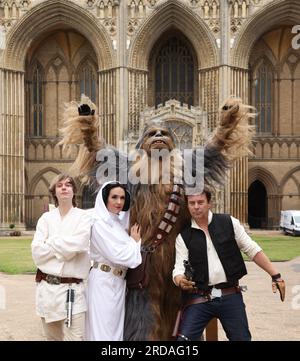 Peterborough, Großbritannien. 18. Juli 2023. Luke Skywalker, Prinzessin Leia, Chewbacca und Han Solo posieren vor der Peterborough Cathedral, bevor eine der größten Star Wars privaten Fansammlungen der Welt in der herrlichen Peterborough Cathedral ab dem 19. Juli zu sehen ist. Die Ausstellung, inoffizielle Galaxien, in der Peterborough Cathedral, umfasst über 120 Ausstellungen, darunter ein lebensgroßer Land Speeder neben seltenen Star Wars-Spielzeugen und -Gegenständen. Peterborough, Cambridgeshire, Großbritannien. Kredit: Paul Marriott/Alamy Live News Stockfoto