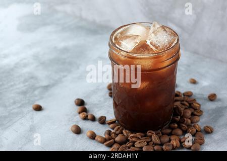 Schwarzer Eiskaffee oder EisAmericano auf grauem Zementtisch. Bereich für Text kopieren Stockfoto