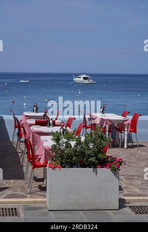 Restauranttische und -Stühle befinden sich an der Küste von Marsalforn an der Küste von Gozo in Malta Stockfoto