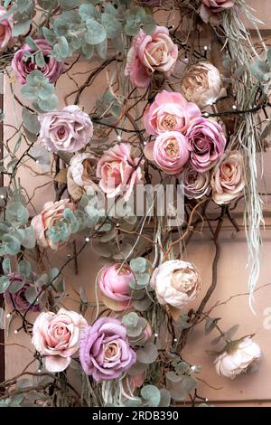 Künstliche Vintage-Blumen, Blatthintergrund für die Einrichtung. Muster aus Seidenrosen, Blätter schmücken den Wandbezug. Wunderschöne Blumenmuster im Retro-Look. Rom Stockfoto