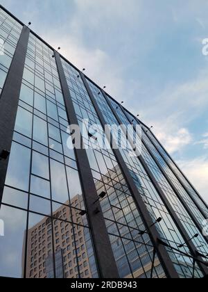 Städtische Reflexionen: Gebäude in einem Gebäudeeffekt. Glasfassade des Bürogebäudes Stockfoto