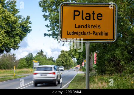 Kennzeichen, Deutschland. 20. Juli 2023. Ein Auto fährt am Eingangsschild nach Plate vorbei, wo Polizeibeamte und Archäologen nach Beweisen für den Diebstahl eines Goldschatzes aus Oberbayern auf einem privaten Grundstück suchen. Nach der spektakulären Verhaftung von vier Verdächtigen, die angeblich den wertvollen Goldschatz aus dem keltischen Römischen Museum in Manching gestohlen haben, wird die Suche nach Teilen der Beute und Beweismaterial in der Nähe von Schwerin fortgesetzt. Kredit: Jens Büttner/dpa/Alamy Live News Stockfoto