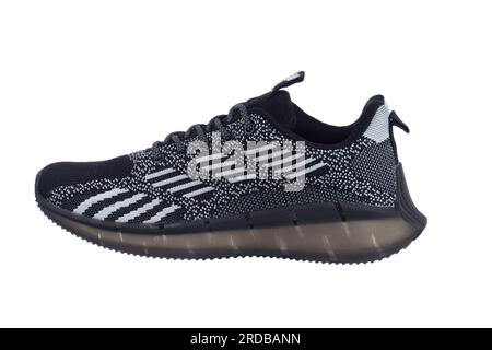 Schwarzer Sneaker mit grauen Streifen auf weißem Hintergrund. Stockfoto