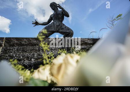 Hongkong, China. 20. Juli 2023 Blumen sind vor der Statue von Bruce Lee in Tsim Sha Tsui zu sehen. Die Regierung Hongkongs feiert den 50. Todestag des Kampfkünstlers Bruce Lee mit einer bedeutenden Ausstellung im Hong Kong Heritage Museum. Die Ausstellung zieht Hunderte von Besuchern an und zollt dem Leben und Vermächtnis des legendären Kampfkünstlers Tribut und fasziniert die Besucher mit Ausstellungen, die seine außergewöhnlichen Leistungen und seinen kulturellen Einfluss zeigen. (Foto: Michael Ho Wai Lee/Alamy Live News Stockfoto