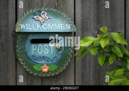 Ein schön dekorierter Briefkasten an einer Holzwand Stockfoto