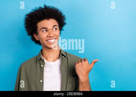 Kreatives Porträt eines jungen Geschäftsmanns, Inhaber eines Unternehmens, Zeigefinger, leerer Raum, neuer Friseur isoliert auf blauem Hintergrund Stockfoto