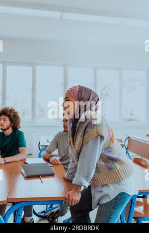 Eine vielfältige Gruppe von Schülern versammelt sich in einem modernen Klassenzimmer und führt leidenschaftlich lebhafte Diskussionen über verschiedene Projekte Stockfoto