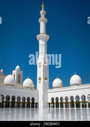 Leuchtend weiße Scheich-Zayid-Moschee mit goldenen Kuppeln am blauen Himmel an einem sonnigen Tag, Abu Dhabi, VAE, Minarett Stockfoto