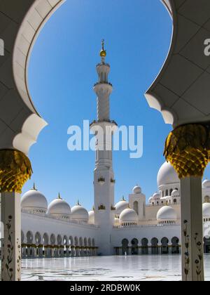 Leuchtend weiße Scheich-Zayid-Moschee mit goldenen Kuppeln am blauen Himmel an einem sonnigen Tag, Abu Dhabi, VAE, Minarett Stockfoto