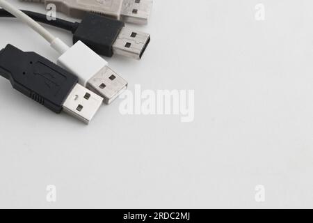 Einige mehrfarbige Kabel mit USB-Anschlüssen auf weißem Hintergrund mit Kopierbereich auf der rechten Seite Stockfoto