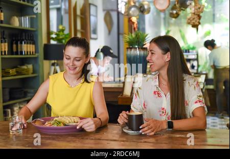 Zwei beste Freunde, die sich unterhalten und in einem Café essen Stockfoto