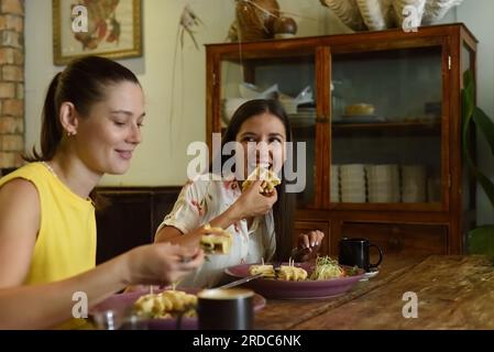 Zwei beste Freunde, die sich unterhalten und in einem Café essen Stockfoto