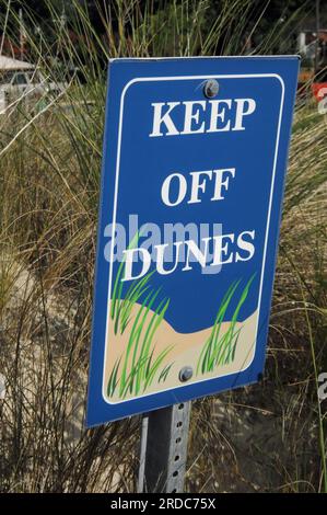 Die Sanddünen von Assateague Island sind durch Metallschilder geschützt, die Einhüllungen warnen, um Gras abzuhalten. Stockfoto