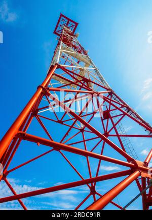 Kommunikationsturm gegen blauen Himmel. Ansicht von unten nach oben. Ein riesiger Kommunikationsmast. Hintergrund. Stockfoto