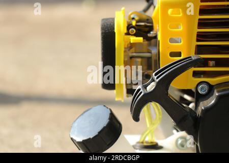 Motorsensen-Maschine mit Schnur zum Starten des Motorsenders mit Blick auf Benzintank und Vergaser. Geräte für die Gartenarbeit Stockfoto