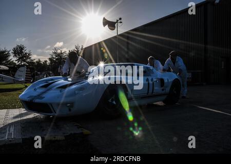 Mechaniker schieben einen klassischen Ford GT40-Rennwagen früh am Morgen zum Goodwood Revival 2013. Veranstaltungsvorbereitung Stockfoto