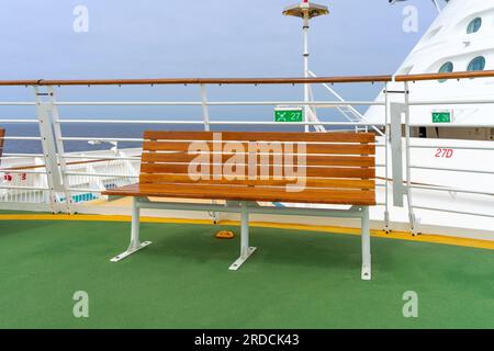 San Pedro, CA, USA – 3. Juni 2023: Eine Holzbank auf dem Hubschrauberdeck des Kreuzfahrtschiffs „Navigator of the Seas“ der Royal Caribbean. Stockfoto