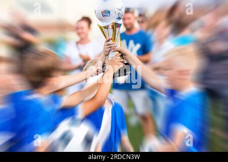 Junge Fußballspieler Mit Trophäe. Junge Sportmannschaft mit Trophäe. Jungs Feiern Sportliche Erfolge. Zur Feier Der Fußball-Meisterschaft. Winn Stockfoto