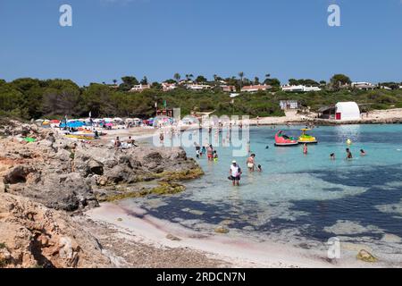 Die Menschen genießen den wunderschönen Strand von Binibeca in der Nähe des Fischerdorfes Binibéquer auf Menorca. Stockfoto