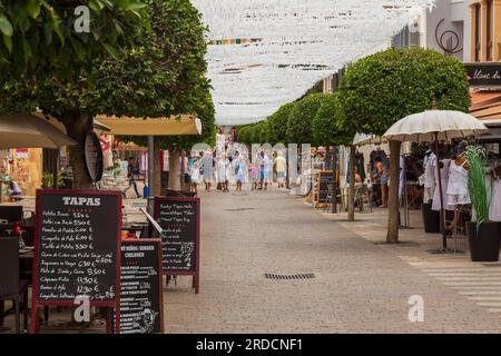 Die Leute gehen durch die gemütliche, enge Straße im historischen Zentrum von Arta, Mallorca, Spanien. Stockfoto