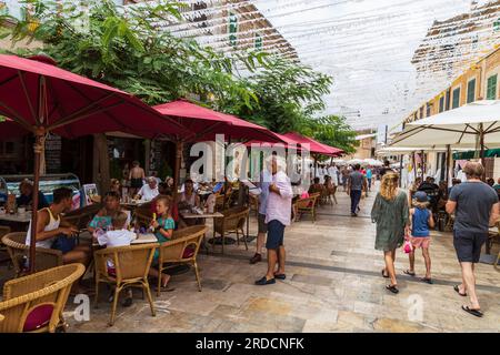 Die Menschen schlendern in einer gemütlichen, engen Straße in der malerischen Stadt Santanyí auf der Mittelmeerinsel Mallorca in Spanien. Stockfoto