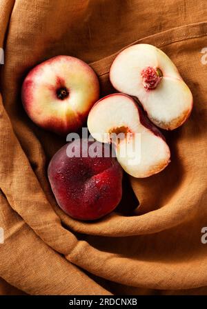 Reife und frische flache Pfirsiche auf einem Leinentuch. Ernte. Obstladen Stockfoto