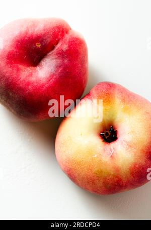 Reifer und frischer, flacher Pfirsich auf weißem Hintergrund. Ernte. Obstladen Stockfoto