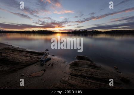 Die Sonne geht über der ruhigen Oberfläche des Lake Lanier im Holly Park unter. Stockfoto