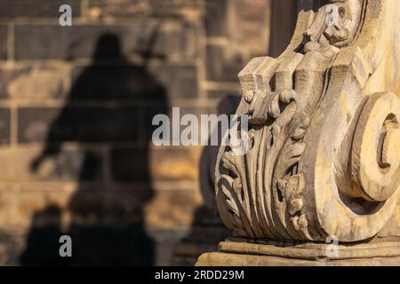 Der Schatten der Statue von St. Johannes von Nepomuk steht vor der Kirche St. James und Agnes in Nysa. Stockfoto