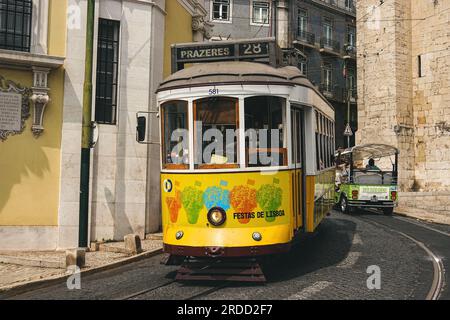 Berühmte gelbe Lissabonner Straßenbahn. Beliebte Straßenbahnlinie 28 im historischen Stadtzentrum von Alfama in Lissabon, Portugal. Stockfoto