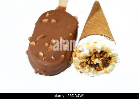 Eiscreme-Vanille-Teller mit Schokoladenstückchen, Nüssen und Karamell in knusprigen Waffeln und Vanilleeis, beschichtet und bedeckt Stockfoto
