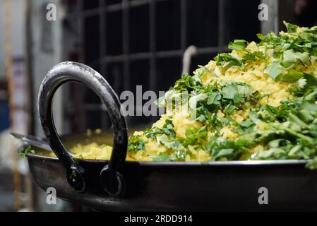 Indischer Snack Poha aus gequetschtem Reis. Poha Jalebi (indische Küche) aus dem indischen Tapri Shop. Bereich Kopieren. Selektiver Fokus. Stockfoto